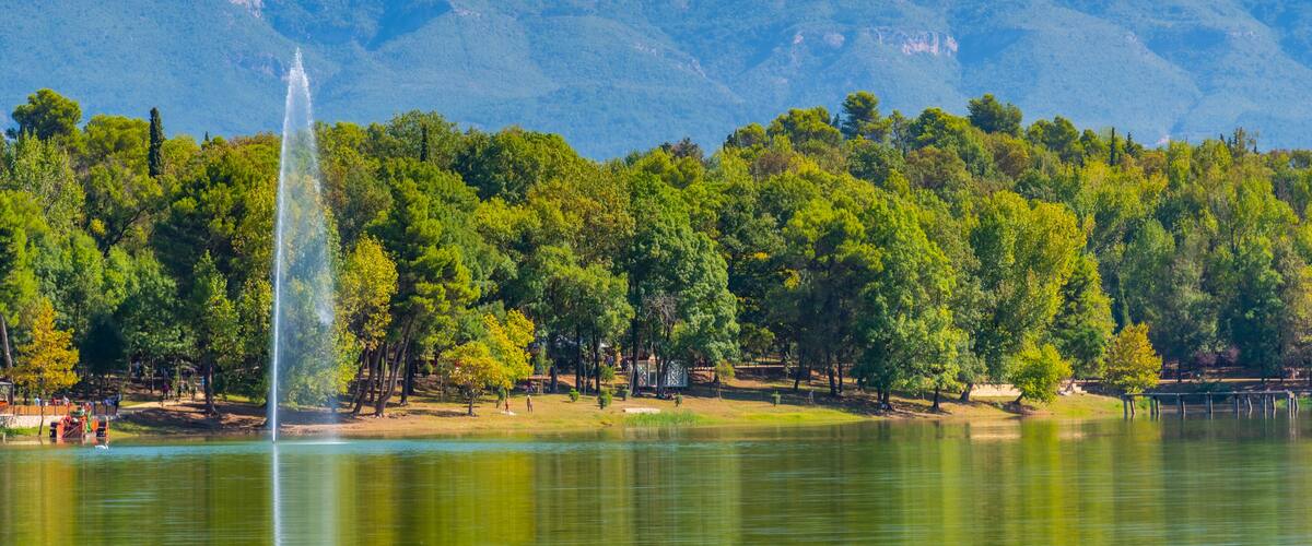 Landscape of Tirana viewed behind a fountain on an artificial lake, Albania