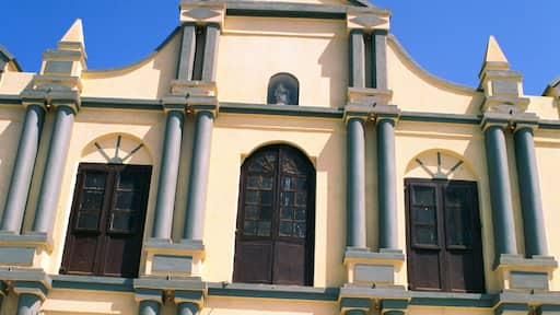 A church with a cross on top, large columns, and arched windows.