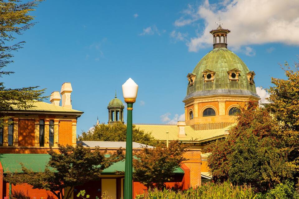 A historic building with a green dome and a red brick facade.