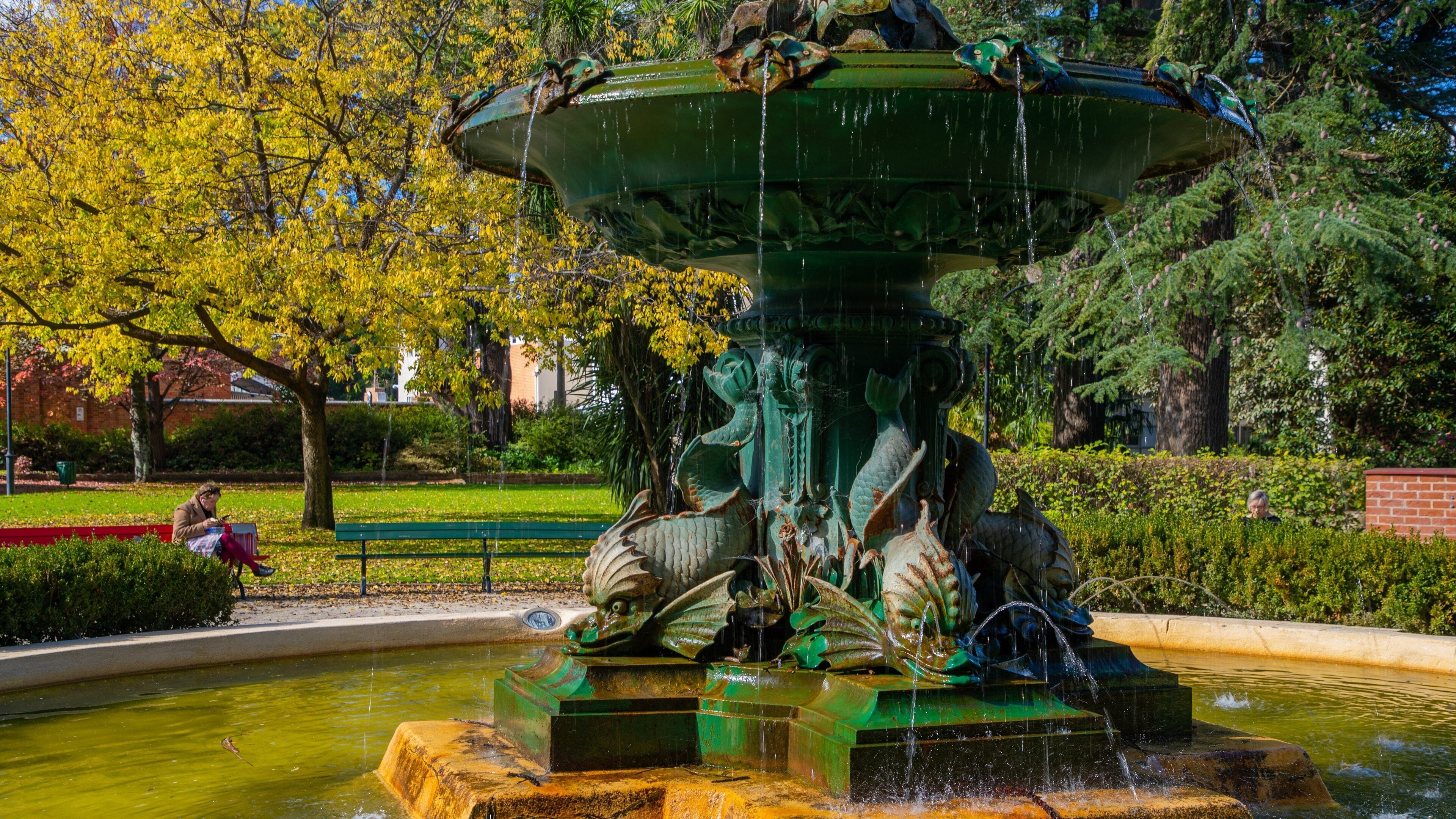 En stor fontæne med en dragefigur i en park.