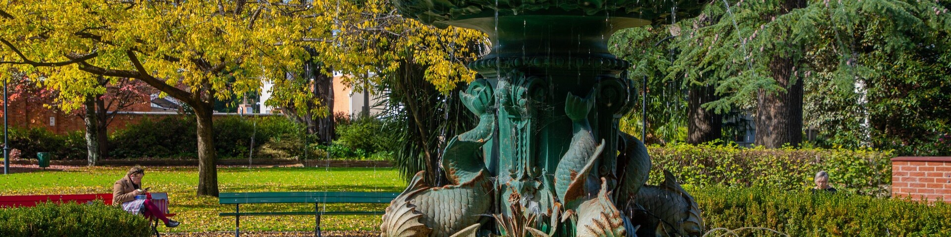 Una gran fuente con una estatua de dragón en un parque.