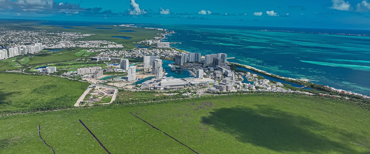 A coastal city with high-rise buildings, a marina, and a large green area.