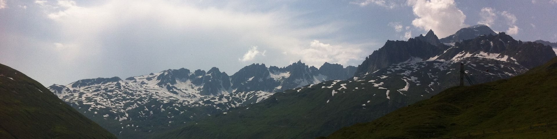 Una carretera de montaña con picos nevados al fondo.