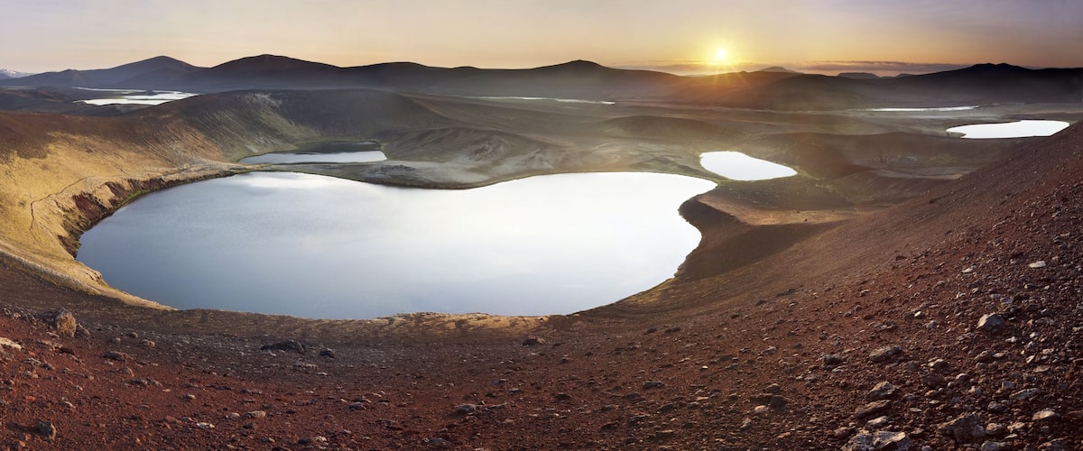 A large crater with a lake surrounded by mountains.