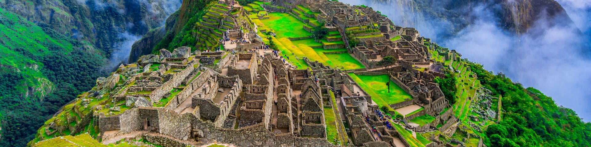 Machu Picchu rodeado de montañas y niebla.