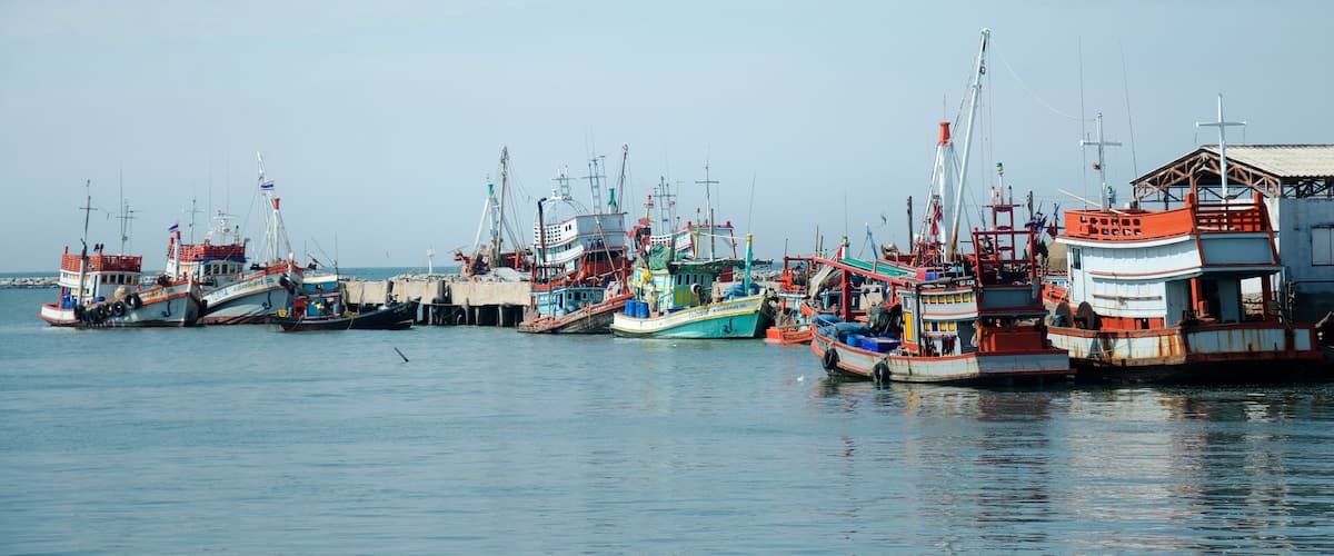 Fishing boat and ship floating in the sea for waiting fishing in night time at Ang Sila in Chonburi, Thailand