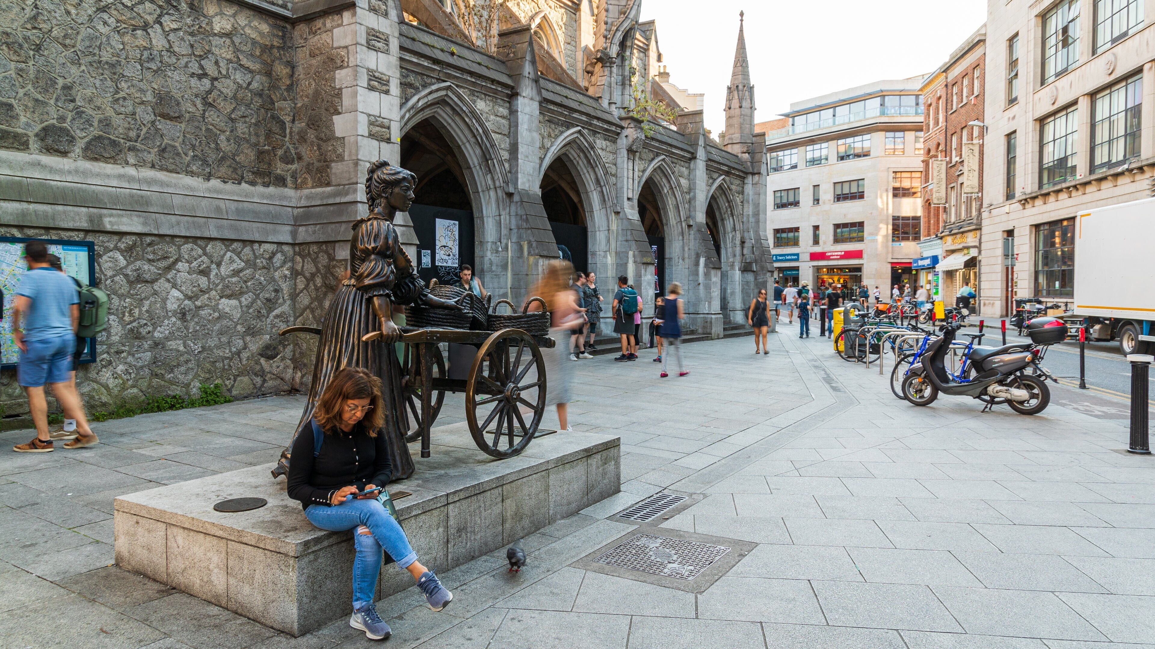 Molly Malone Statue featuring a city, heritage architecture and street scenes