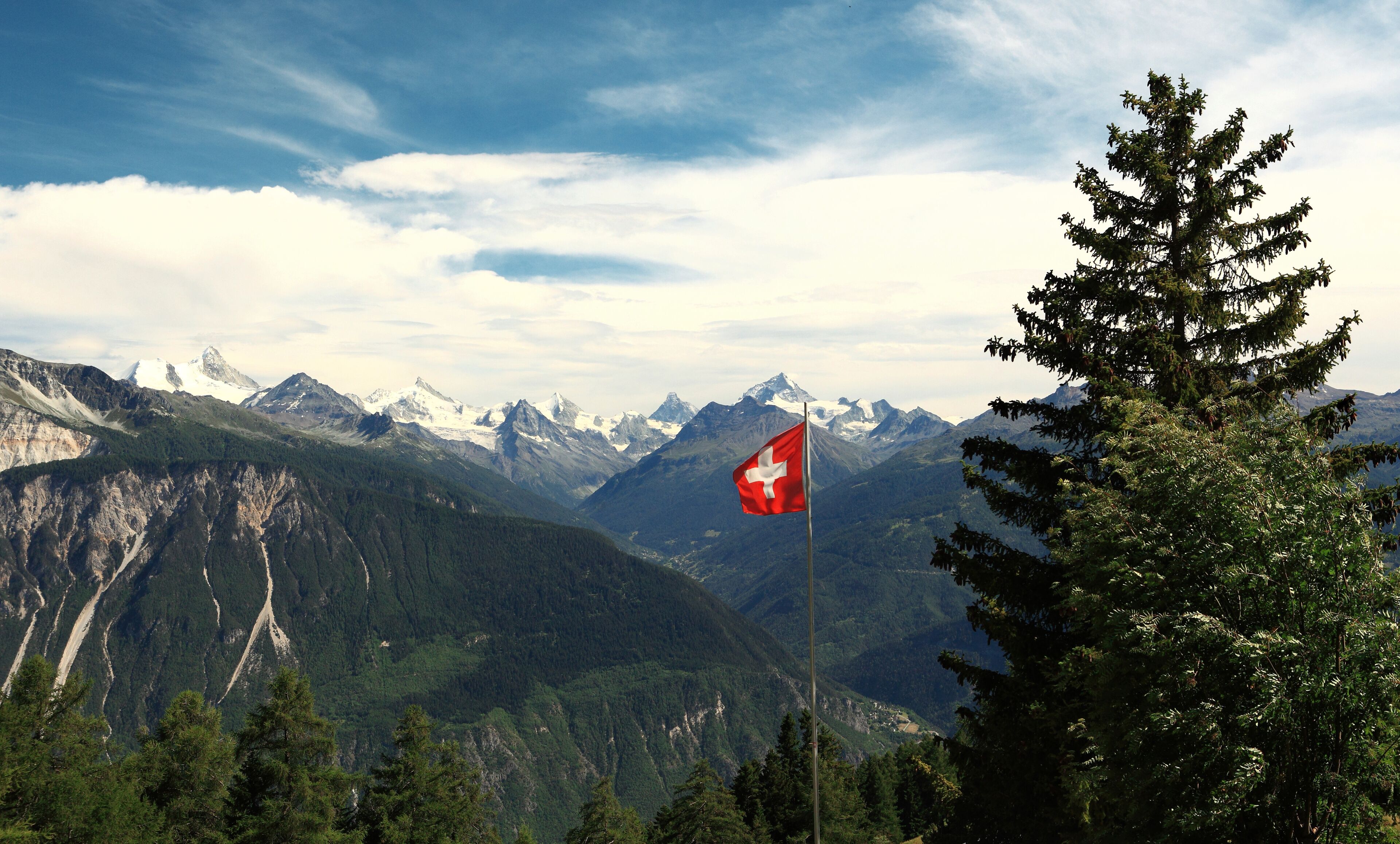 A mountainous landscape with a Swiss flag.