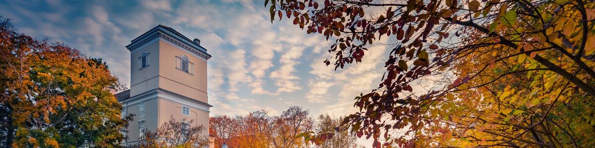 Calm autumn sunrise of Wolkersdorf Castle on the shore of castle pond. Colorful morning cityscape of Wolkersdorf town, town in the district of Mistelbach in the state of Lower Austria, Europe.