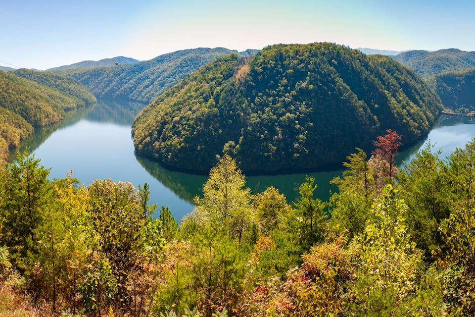 A lake surrounded by forested hills.