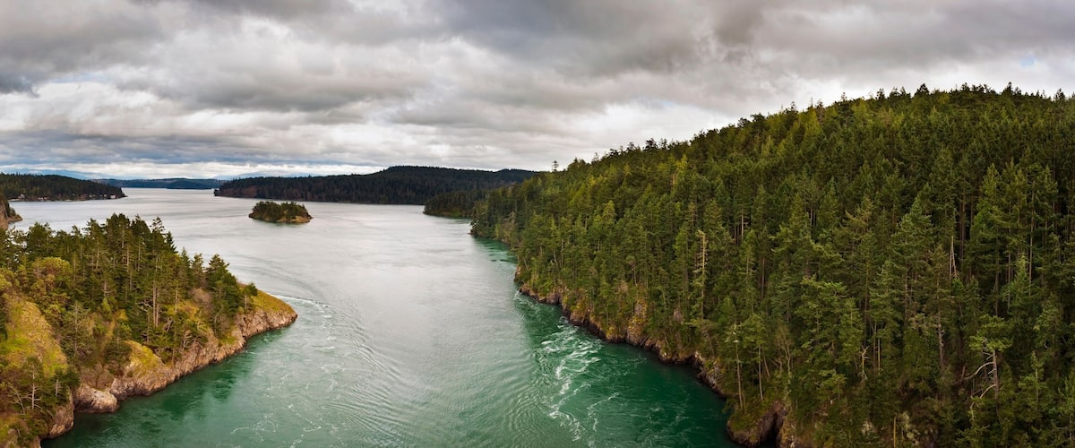 A river surrounded by dense forests and rocky cliffs.