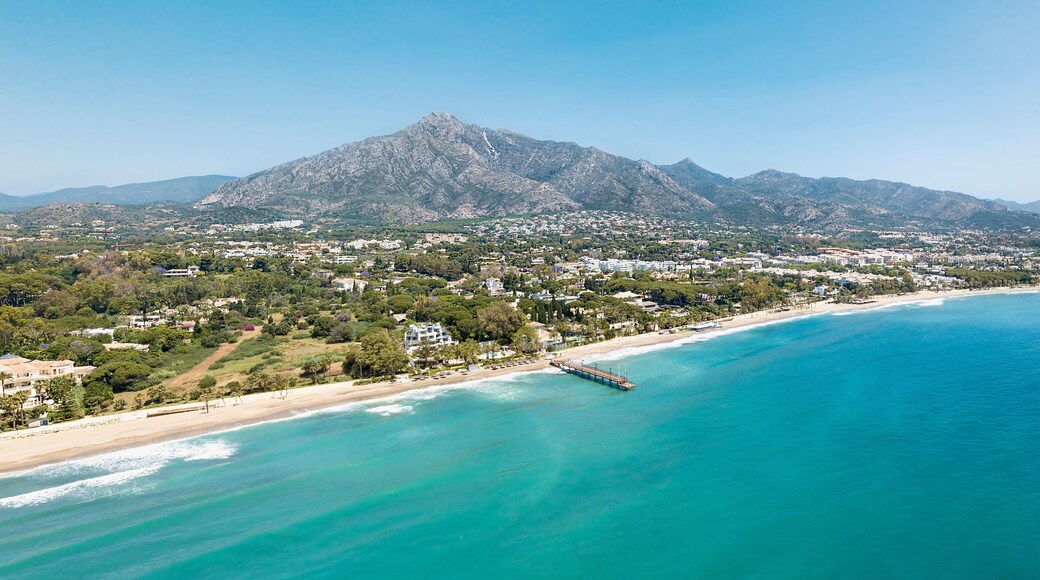 Unique aerial view of luxury and exclusive area in Marbella, golden mile beach, view of Puente Romano Bridge and in background famous La Concha mountain. Emerald water colour