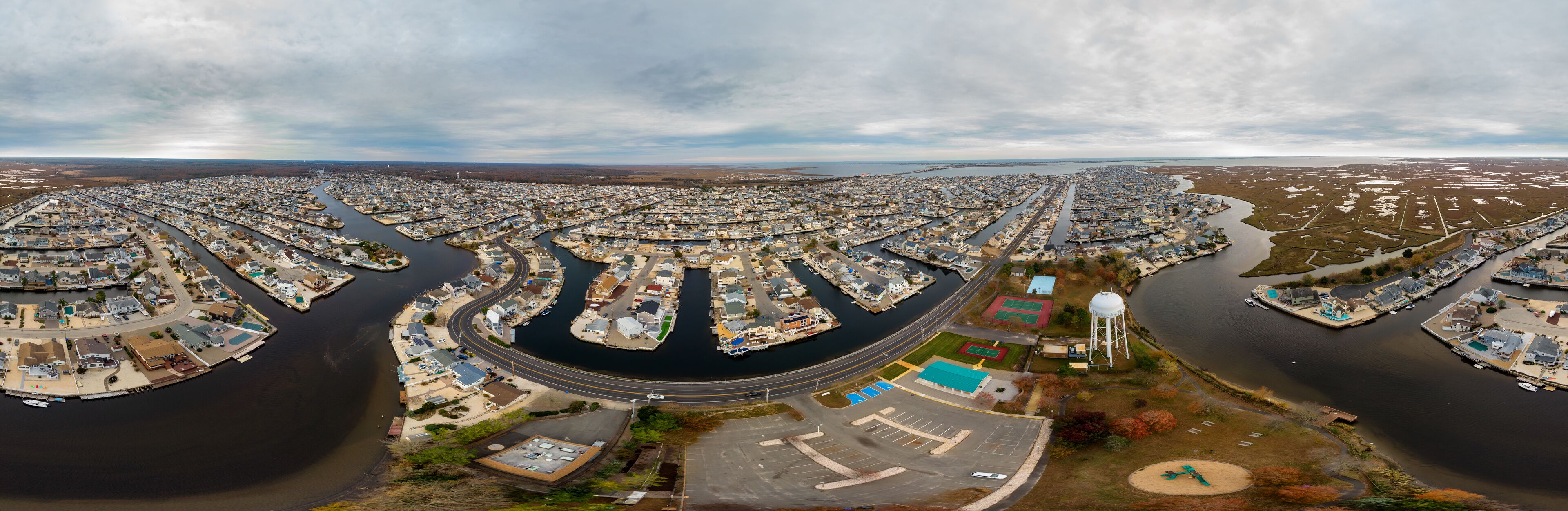 An aerial view of a residential area with a river running through it, surrounded by houses and docks.