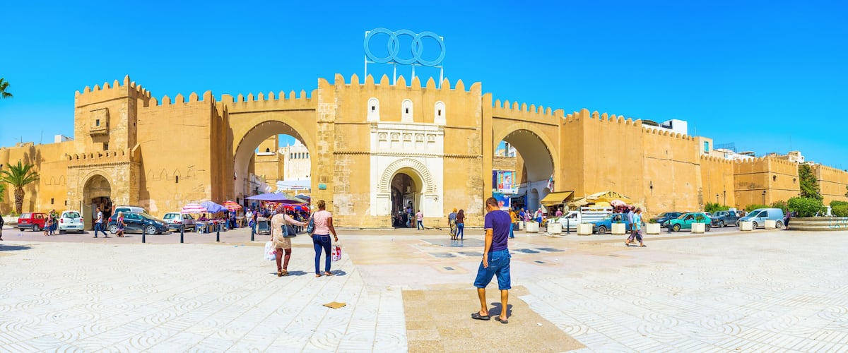 A historic fort with large archways and a prominent Olympic rings symbol.