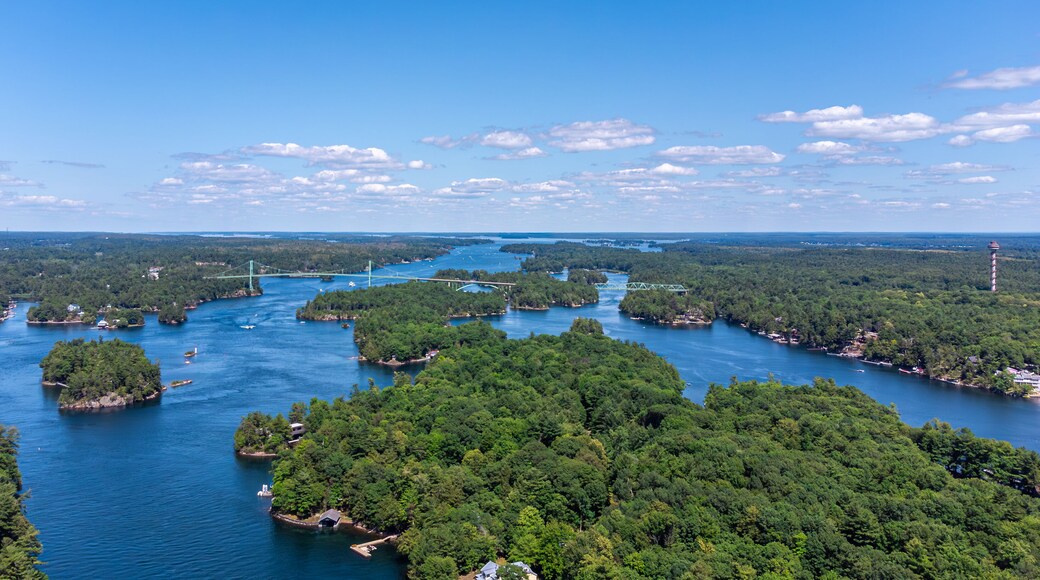 Aerial view of the Saint Lawrence River, Thousand Islands Bridge and 1000 Islands Tower, capturing lush green islands, blue water, and the Canada–US international border on summer day (July 2021)