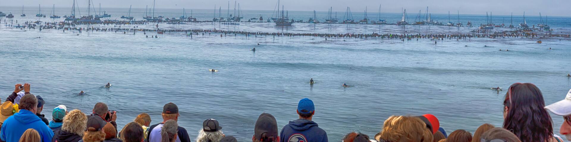 A crowded beach with numerous boats and people.