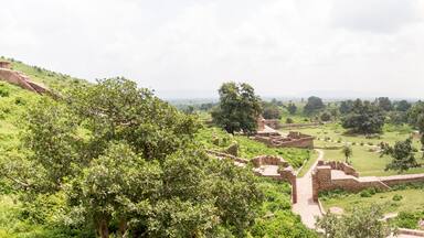A historical site with ruins and lush greenery.