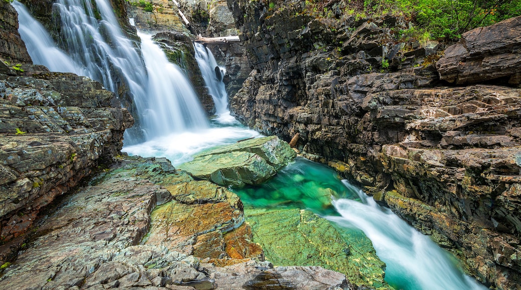Une cascade à plusieurs niveaux dévalant un terrain rocheux dans une eau claire.