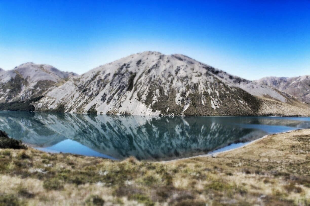 A mountain range with a lake reflecting the mountains.