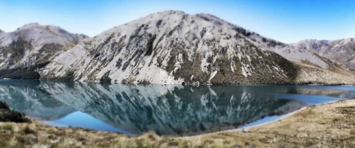A mountain range with a lake reflecting the mountains.