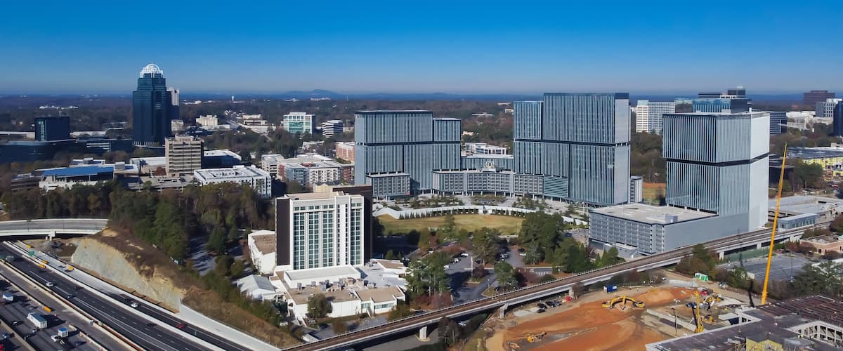 A cityscape with modern skyscrapers, a highway, and a bridge.