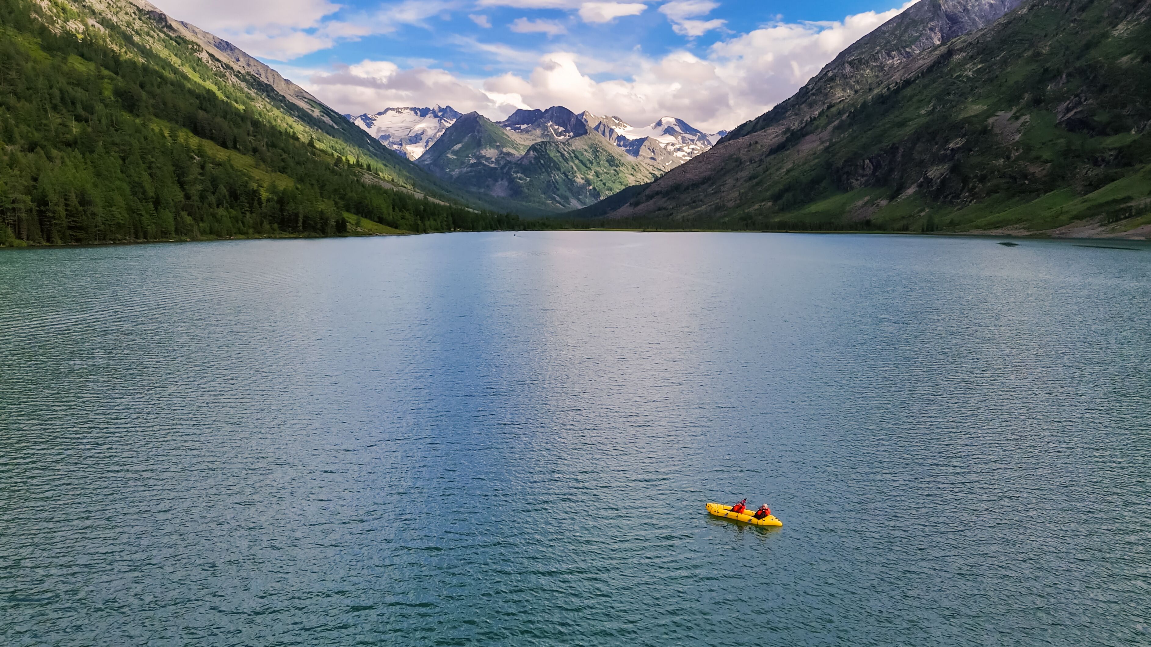 yellow pack raft on the Multinsky mountain lake in Altai