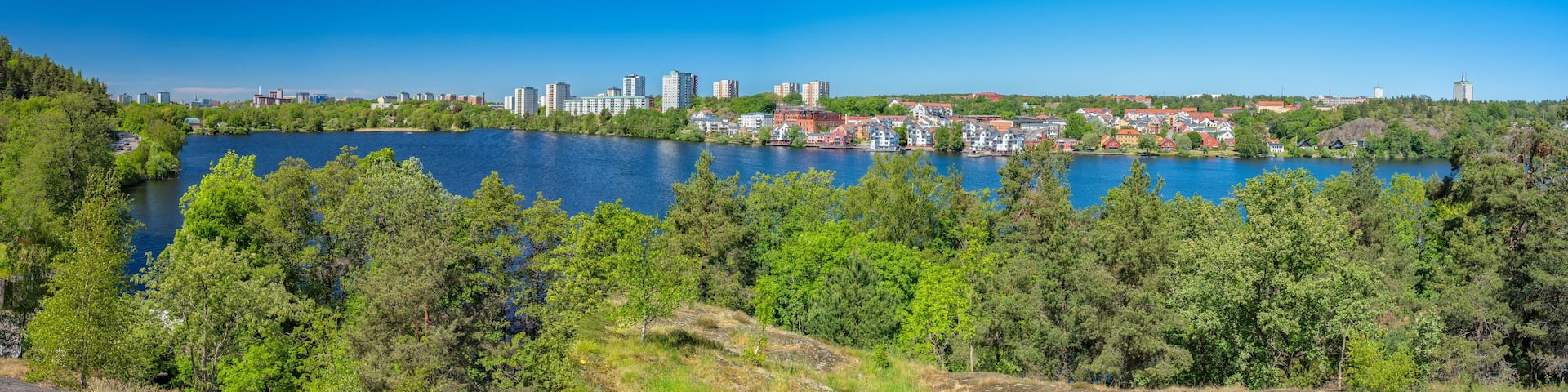 A panorama of the Jaerla lake and the Jaerla area in Nacka municipality and some buildings in Stockholm city furthest away in the background