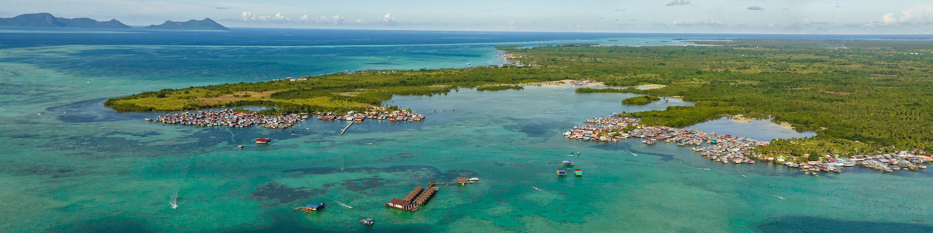 Aerial drone of coast of the island Bum Bum with towns and villages. Semporna, Sabah, Malaysia.