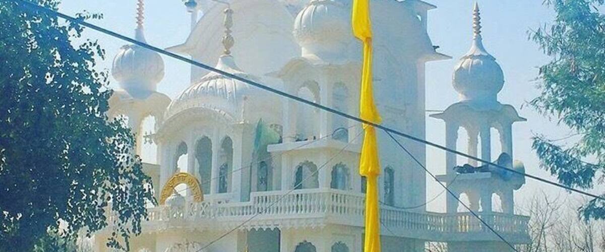 A large white building with multiple domes and golden spires.