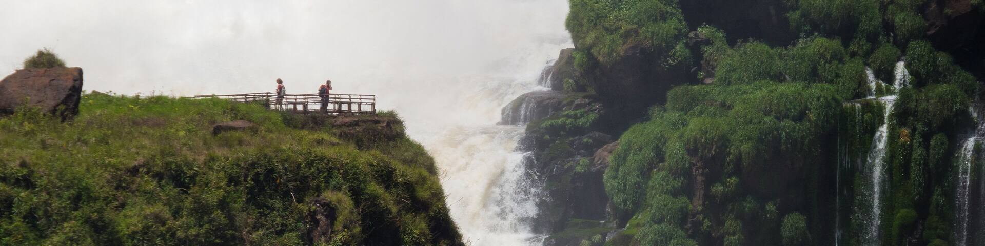 Tourists near huge waterfall at Iguazu National Park, Argentina