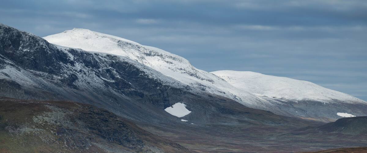 Dusting of autumn snow coveres AmmarfjÀllet mountains in VindelfjÀllen nature reserve from Kungsleden Trail, Lapland, Sweden