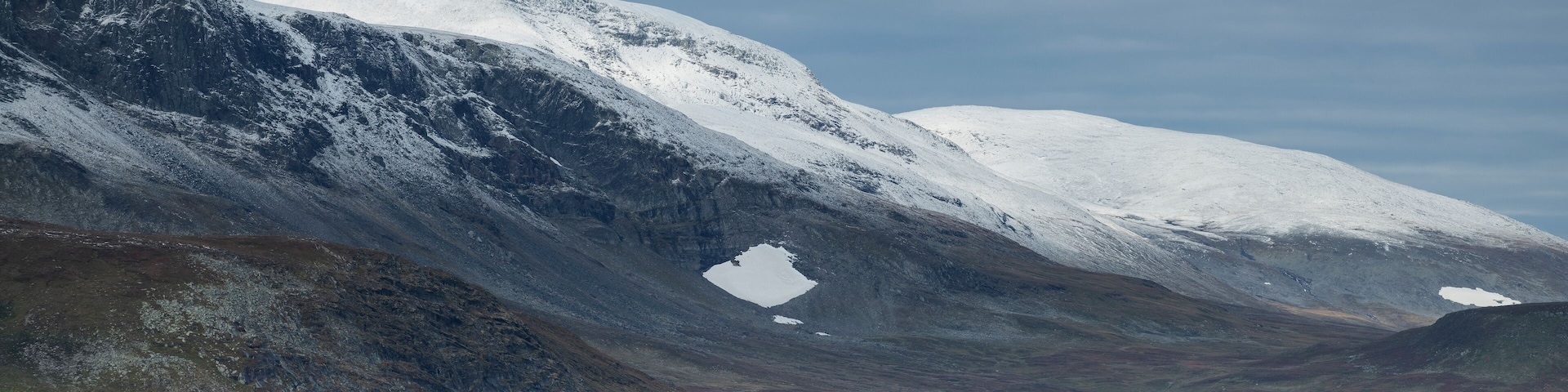 Dusting of autumn snow coveres Ammarfjället mountains in Vindelfjällen nature reserve from Kungsleden Trail, Lapland, Sweden