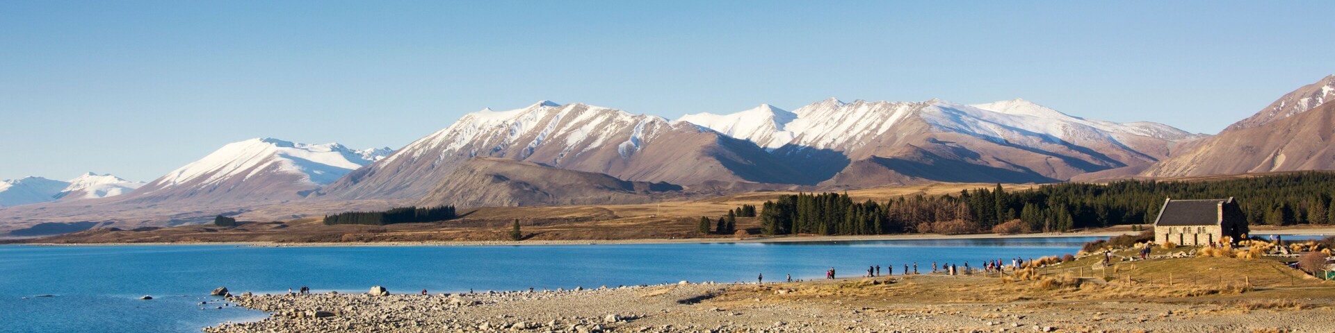 View on picturesque Lake Tekapo with its special blue color. Lake Tekapo is on the South Island of New Zealand, the Mackenzie district, Canterbury Region. Visible is the Church of the Good Shepherd.