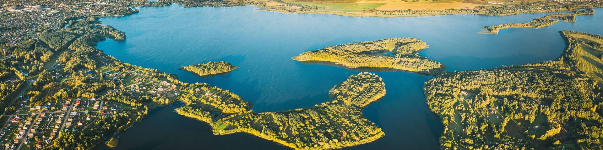 Lyepyel, Lepel Lake, Beloozerny District, Vitebsk Region. Aerial View Of Lyepyel Cityscape Skyline In Autumn Morning. Morning Fog Above Lepel Lake. Top View Of European Nature From High Attitude In