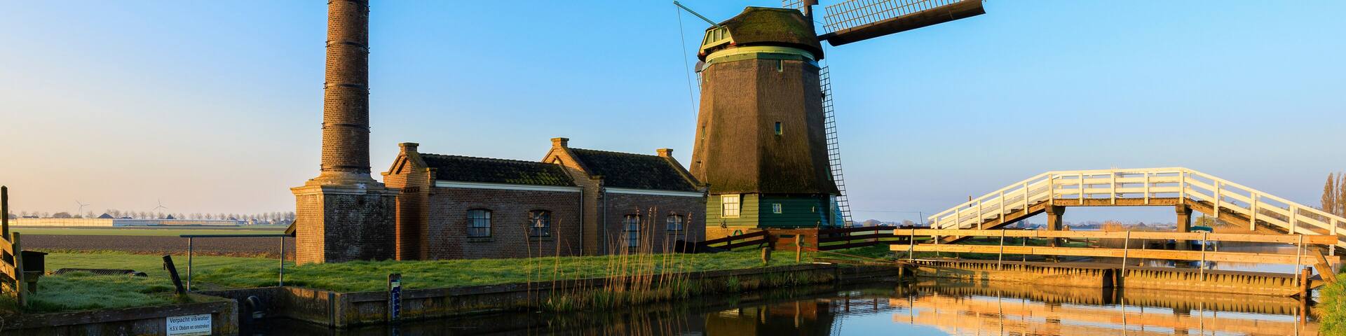 Typical windmill reflected in the canal at dawn Berkmeer municipality of Koggenland North Holland The Netherlands Europe