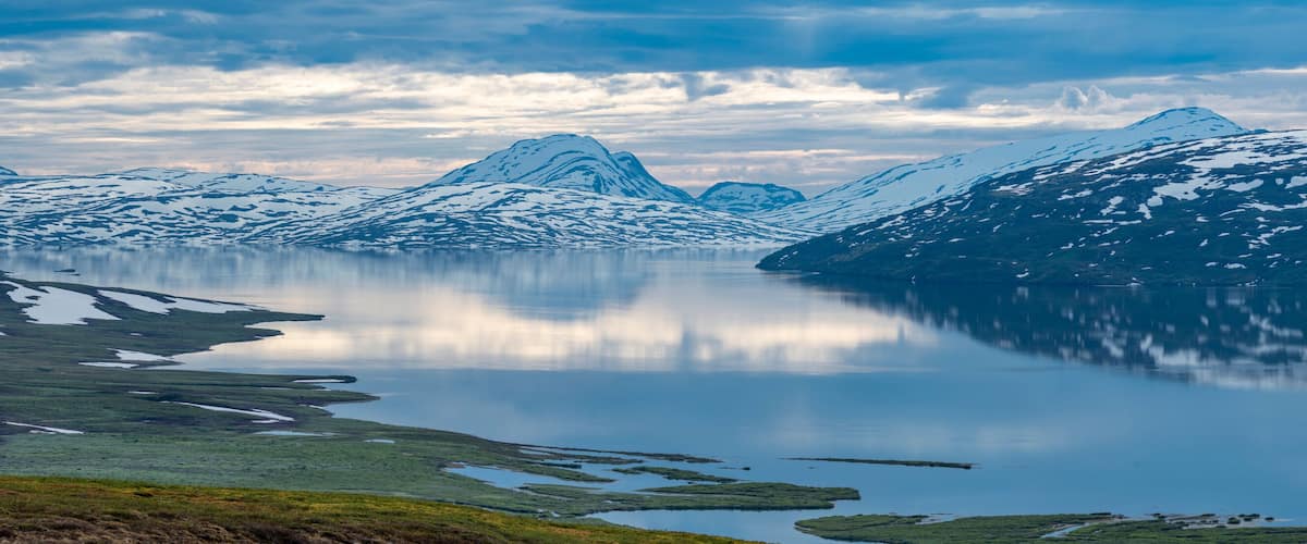 Beautiful Horizontal landscape North of the Arctic Circle in Swedish Lapland overlooking Big lake Vastenjaure on the Padjelanta Trail and The Border to Norway and Fjords reflection in the Water.