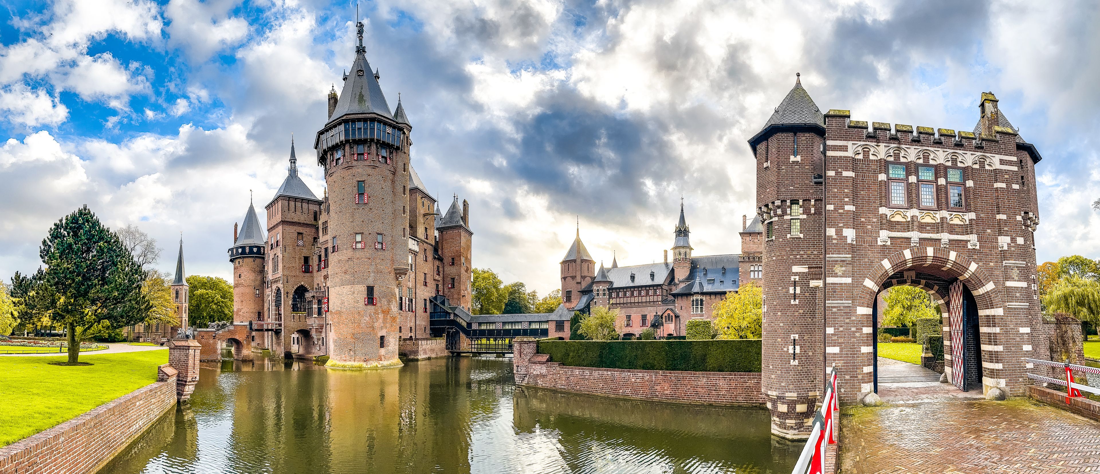 Un château historique doté de nombreuses tours et entouré de douves.