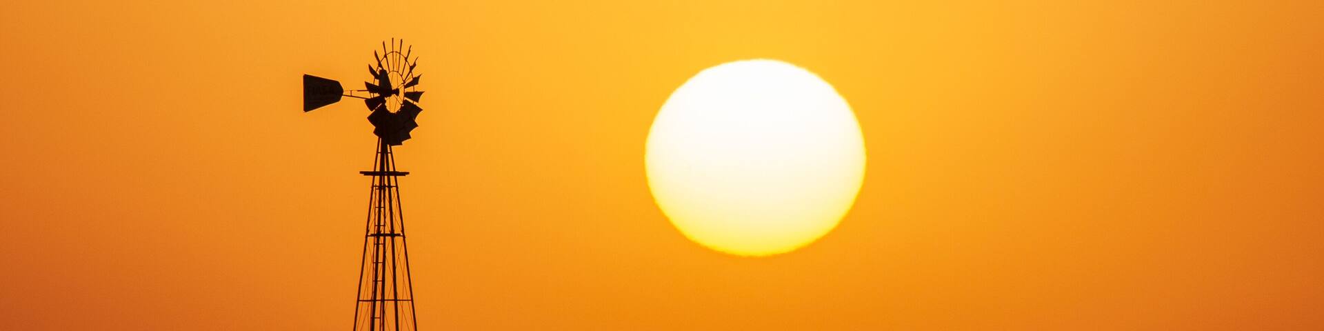 Windmill in countryside at orange sunset, Pampas, Patagonia,Argentina.