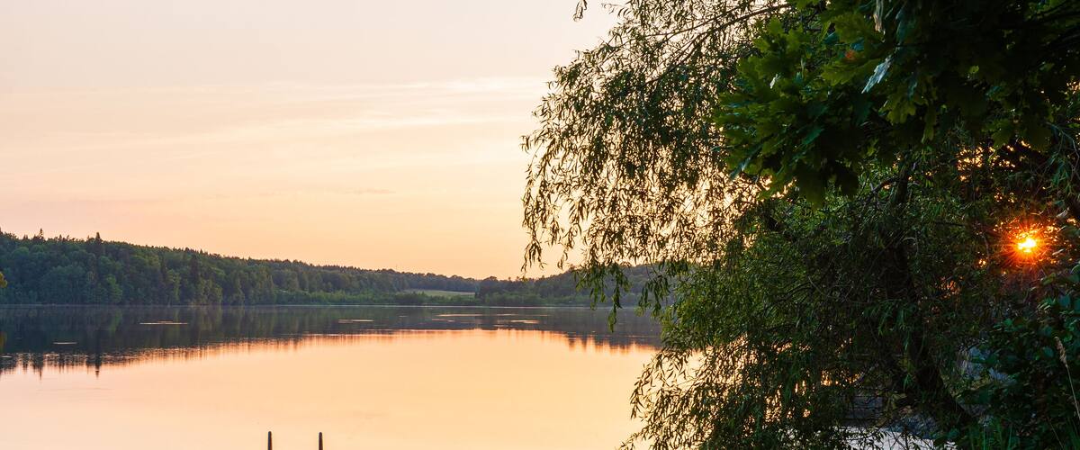 Moored boat on still water at sunset. Ă
tvidaberg, Sweden.