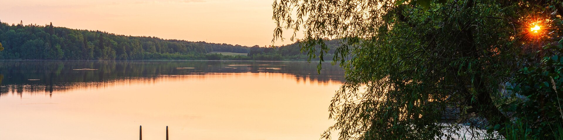 Moored boat on still water at sunset. Åtvidaberg, Sweden.