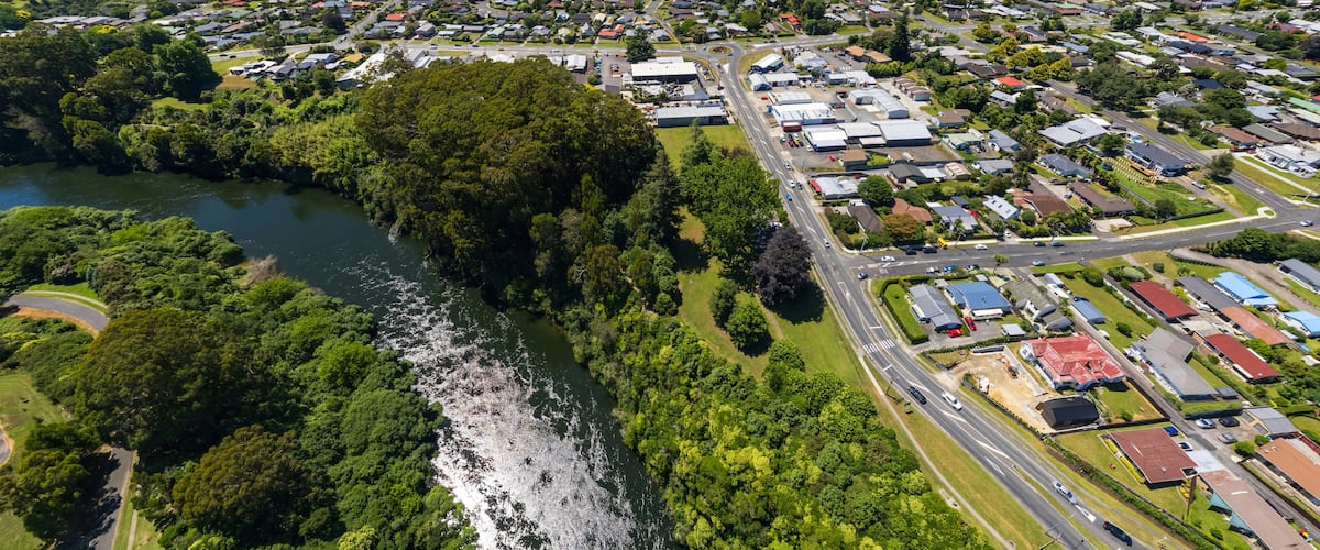 A river winding through a town with residential and commercial buildings.