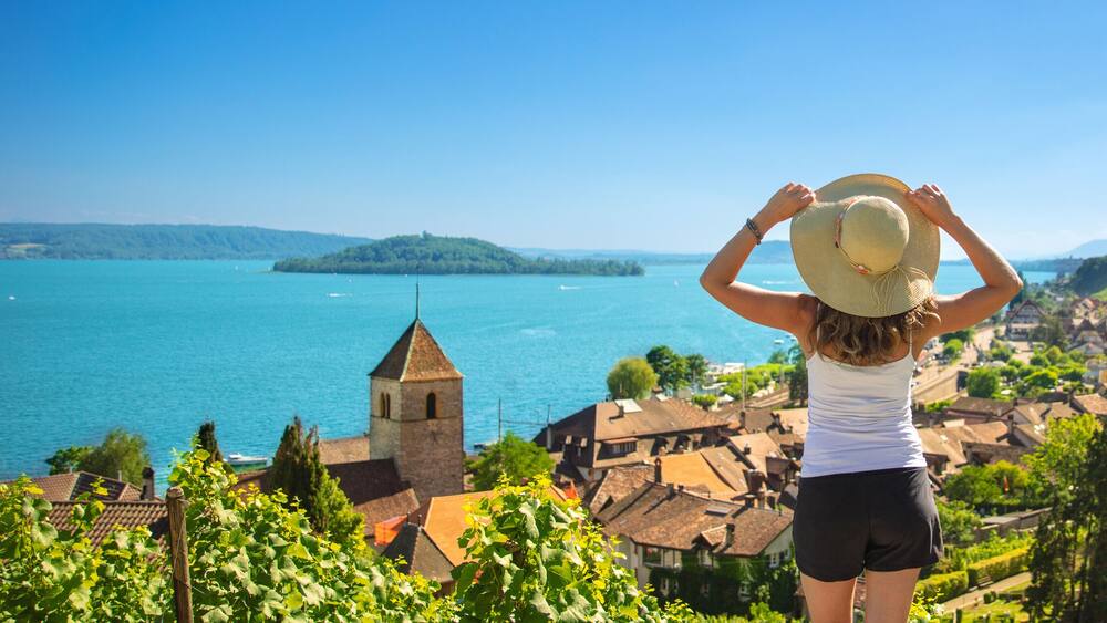 Beautiful landscape view of lake with woman tourist in Switzerland- Village, vineyard and lake