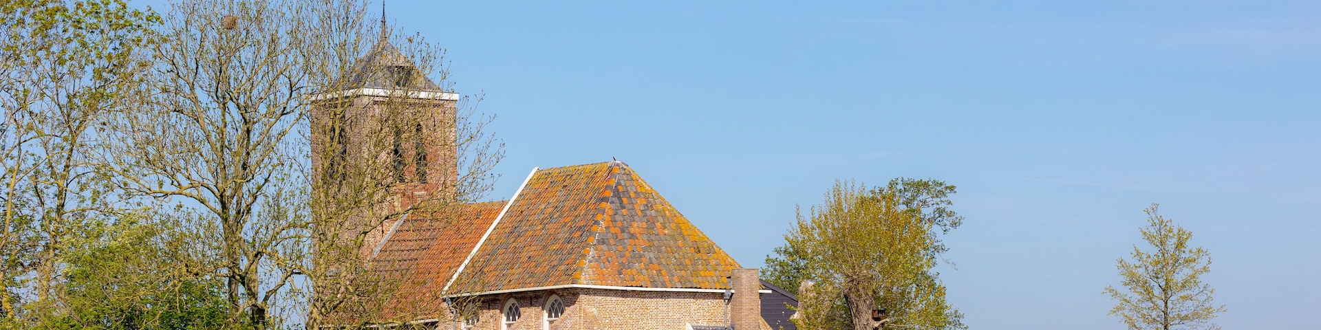 Typical polder in spring with green grass meadow, Theaterkerk (Church) Wadway is a village in the Dutch province of North Holland. It is a part of the municipality of Opmeer and Medemblik, Netherlands