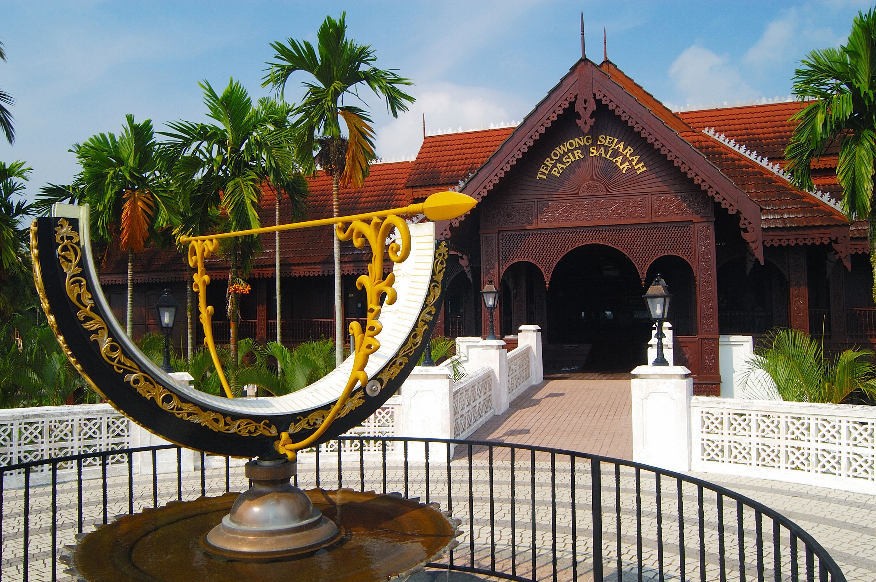 A traditional building with ornate architecture and a large decorative fountain in the foreground.