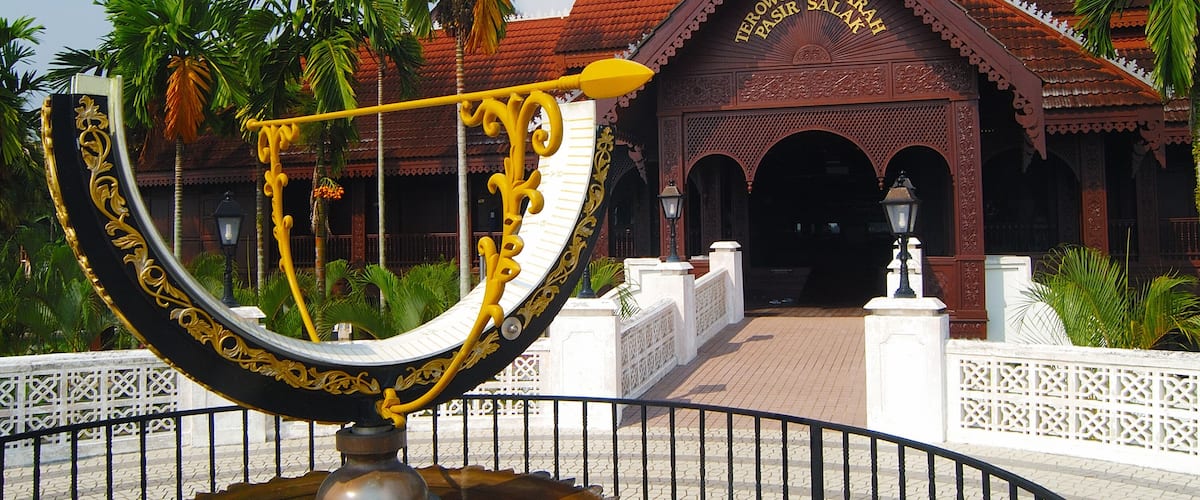 A traditional building with ornate architecture and a large decorative fountain in the foreground.