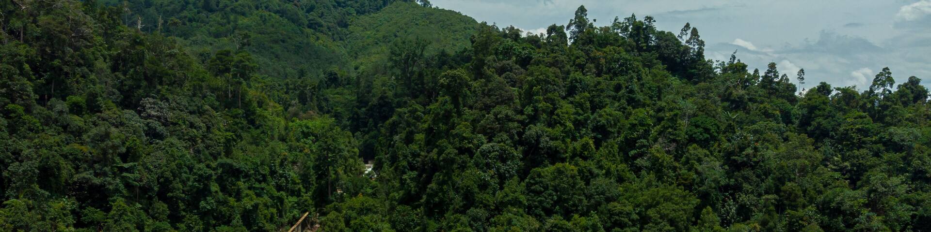 Aerial drone view of falling water from high angle view at Lata Berangin Waterfall, Kuala Krai, Kelantan, Malaysia.