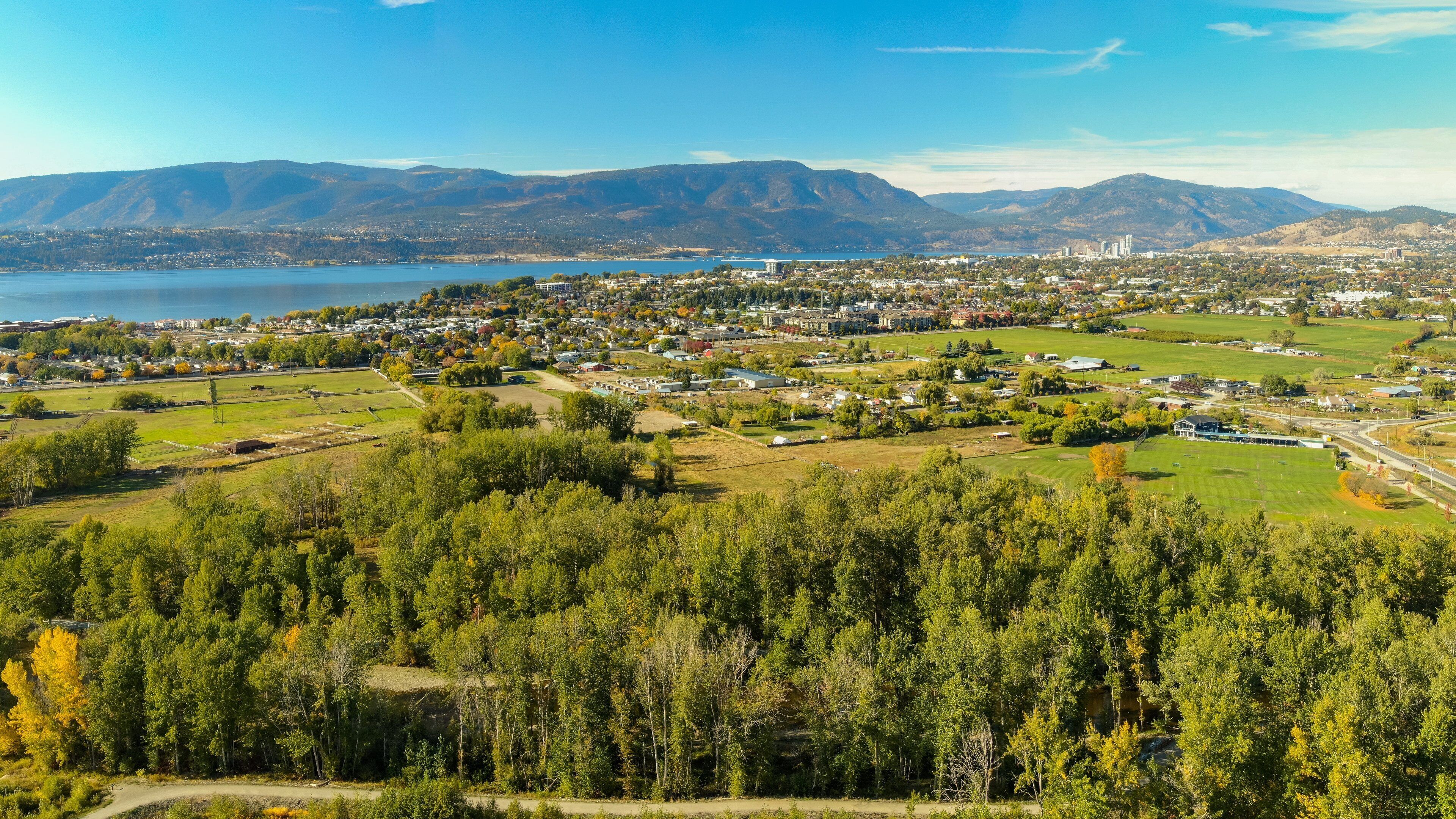 Une ville située près d’un lac, entourée de montagnes et d’une forêt dense.