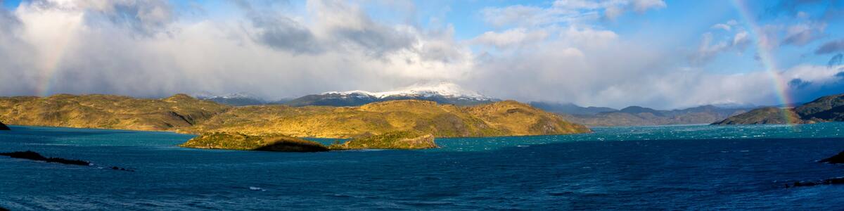 Chile, Ultima Esperanza Province, Scenic panorama of rainbow over shore of Lake Pehoe