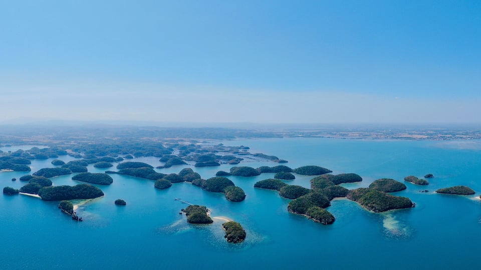 An aerial view of a cluster of islands surrounded by clear blue waters.