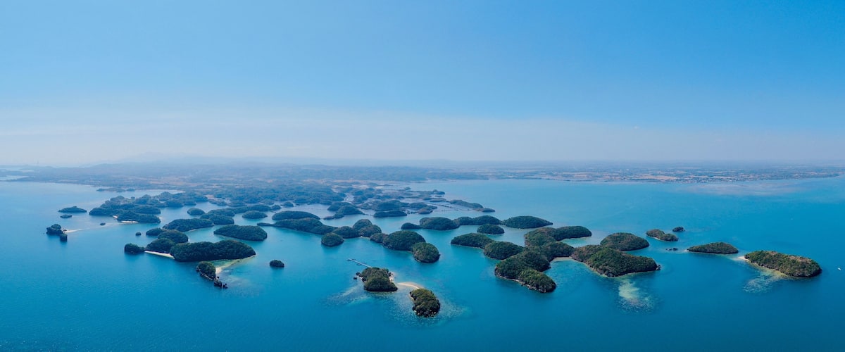 An aerial view of a cluster of islands surrounded by clear blue waters.